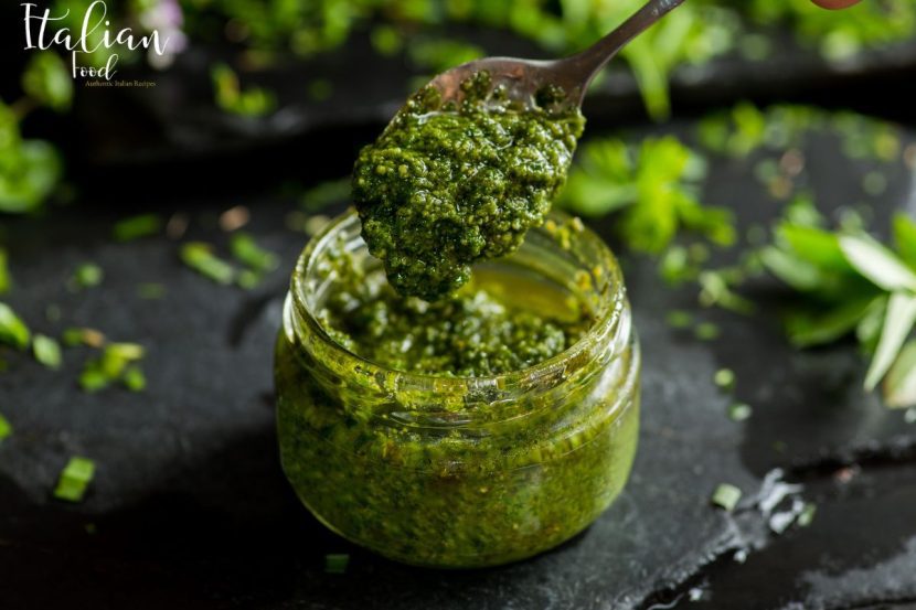 A bowl of vibrant green Thermomix Pesto alla Genovese garnished with fresh basil leaves.
