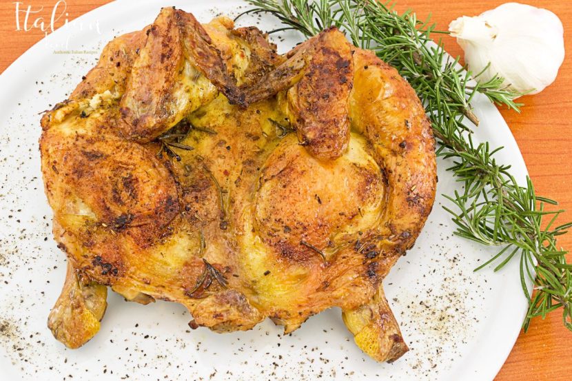 A plate of Pollo alla Diavola with crispy skin and roasted vegetables.