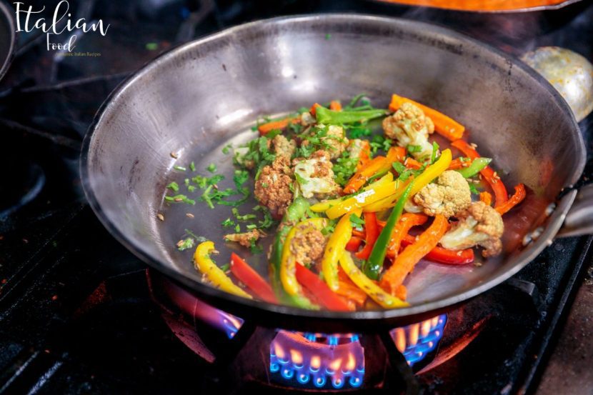 Chef sautéing vegetables in a pan