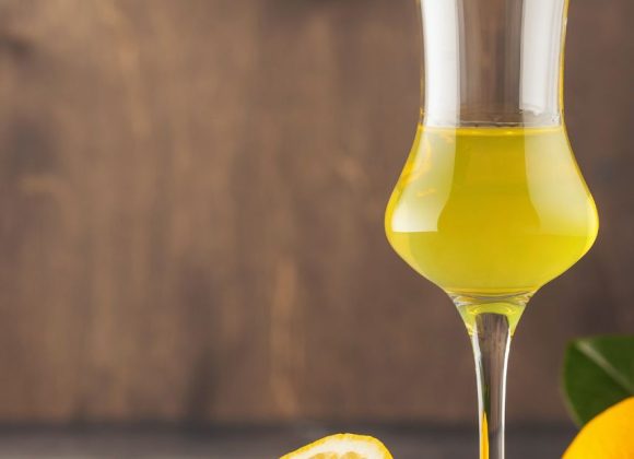 A bottle of traditional Limoncello with fresh lemons.